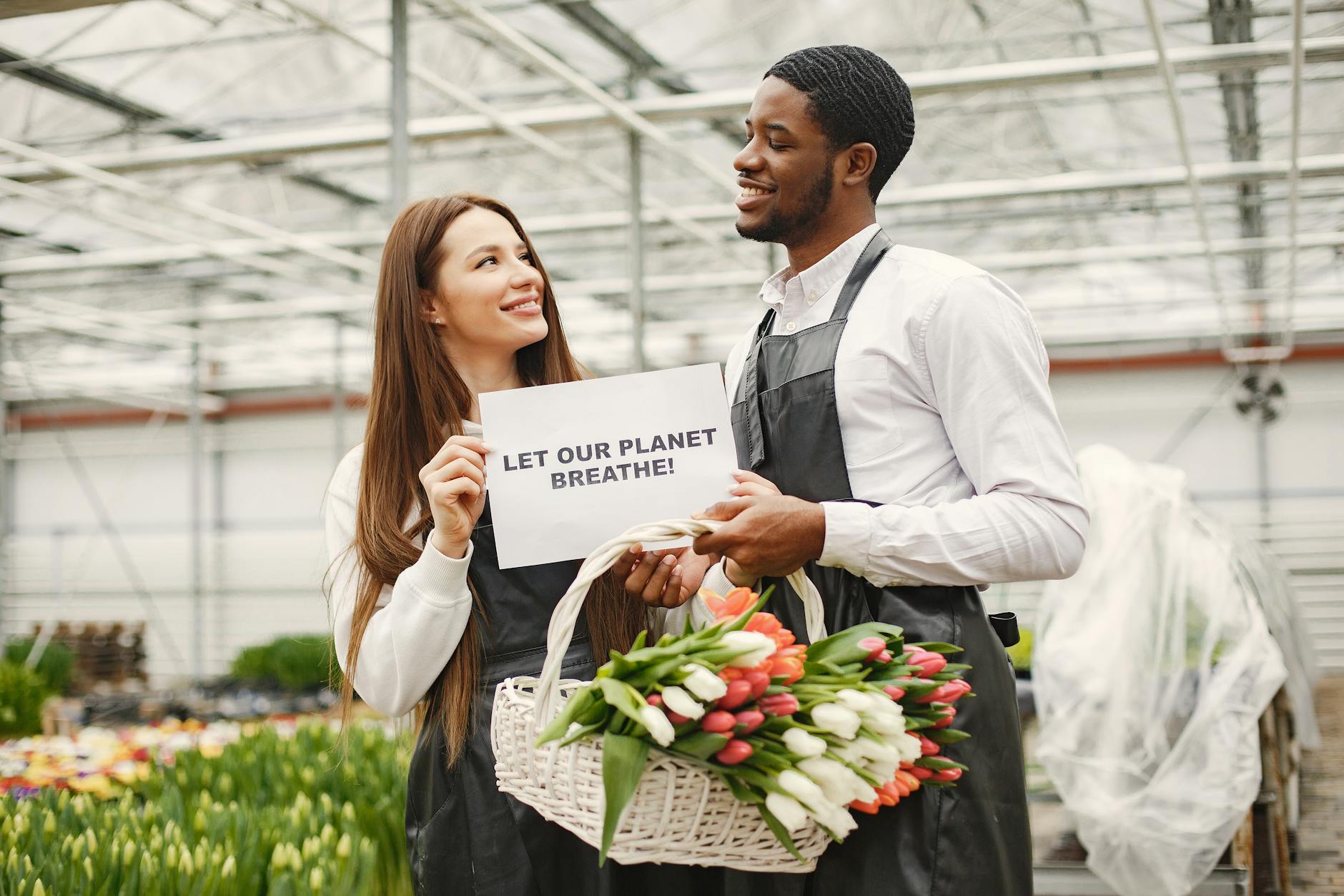 a man and a woman standing beside each other while holding white paper with message