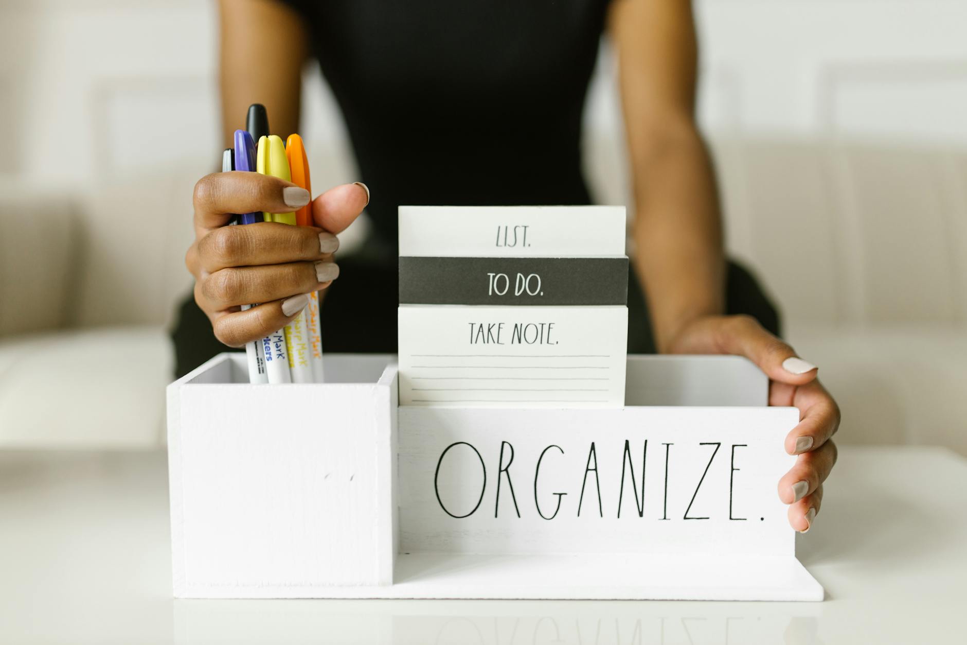 person holding pens and a white organizer